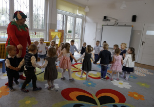 Dzieci tańczą w kole z nauczycielką
